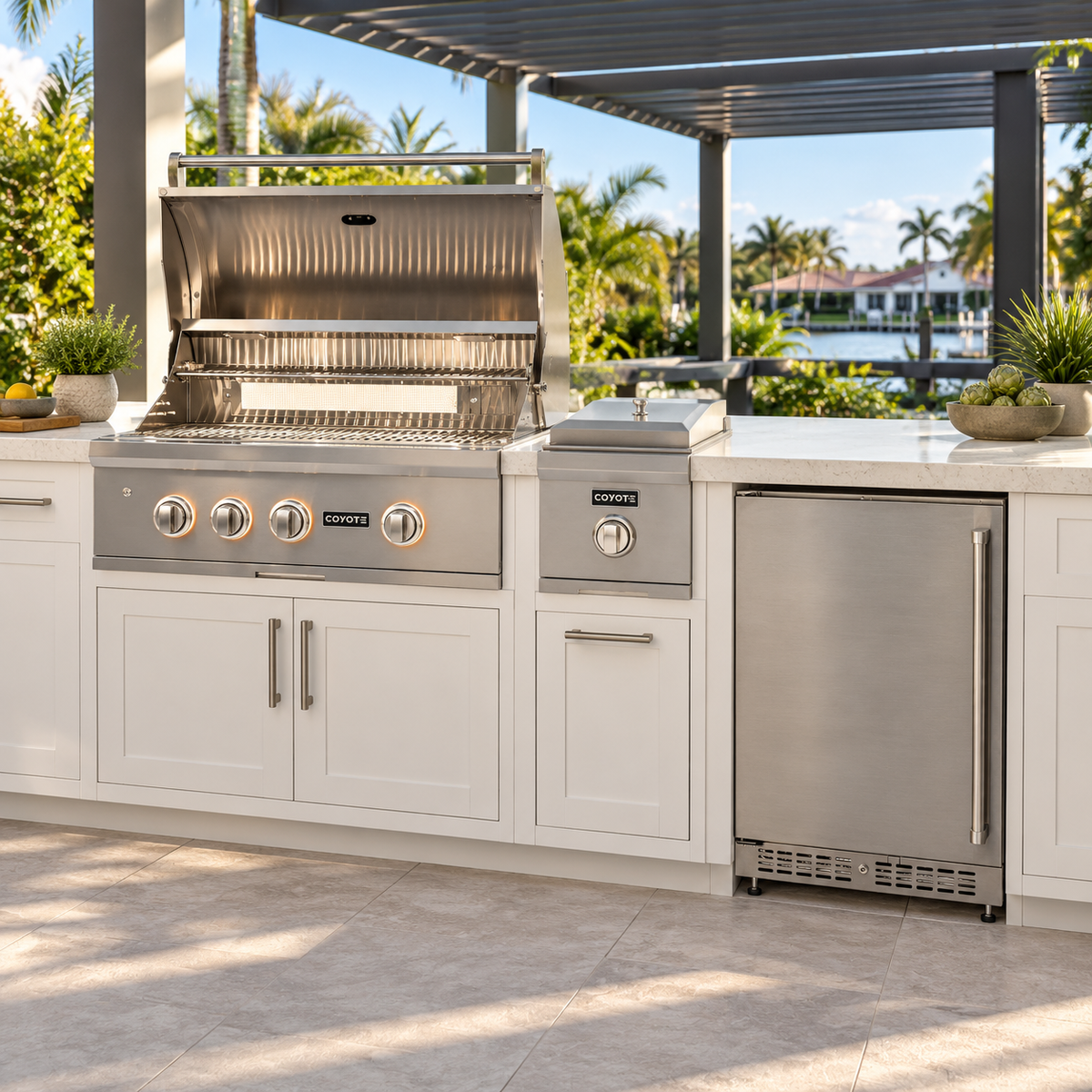 Coyote Backyard Chef Package – 30" Grill, 24" Refrigerator & Single Side Burner installed in an outdoor kitchen; cabinetry and setting shown for inspiration