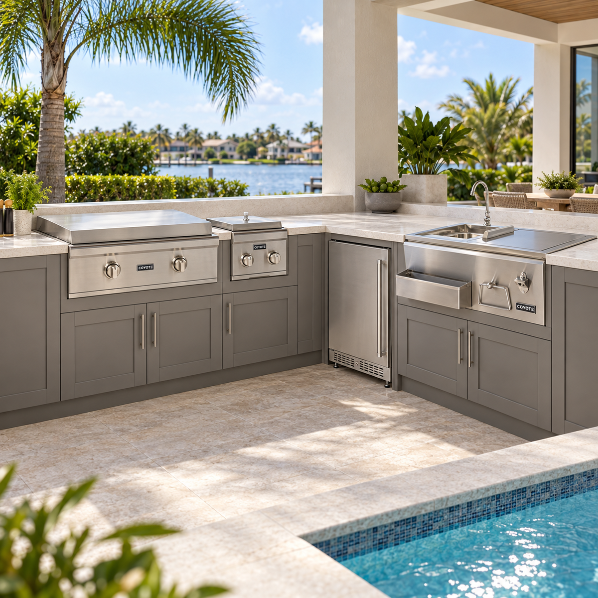 Coyote Deluxe Griddle Entertainer Package – 30" Griddle, 24" Refrigerator, Double Side Burner & 30" Refreshment Center installed in an outdoor kitchen; cabinetry and setting shown for inspiration