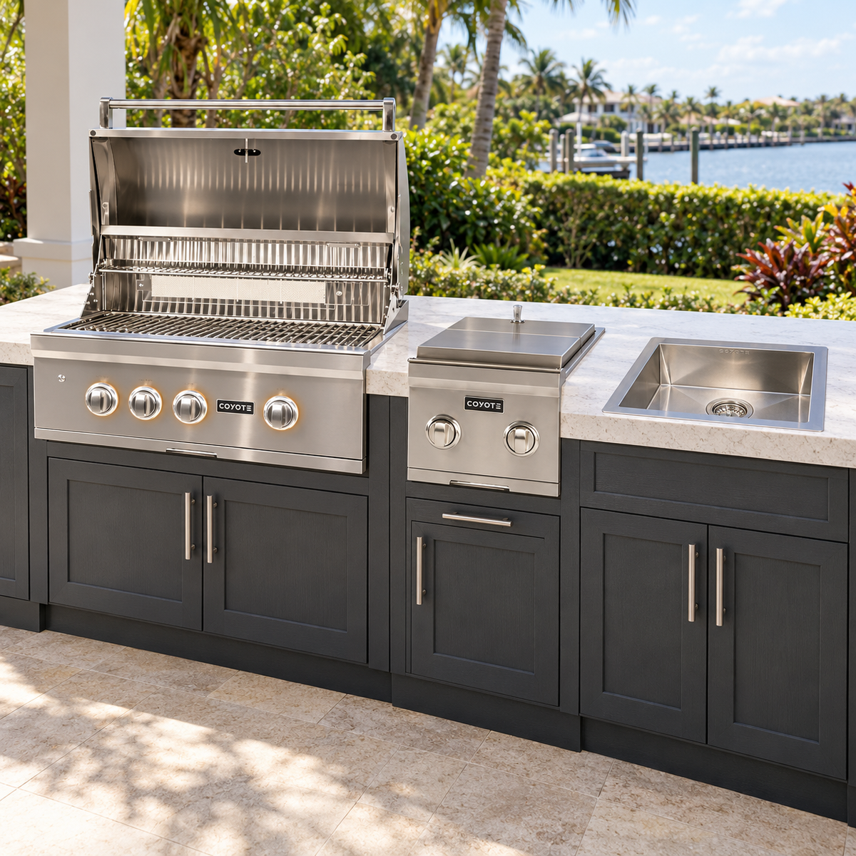 Coyote Double Duty Package – 30" Grill, Double Side Burner & Drop-In Sink installed in an outdoor kitchen; cabinetry and setting shown for inspiration