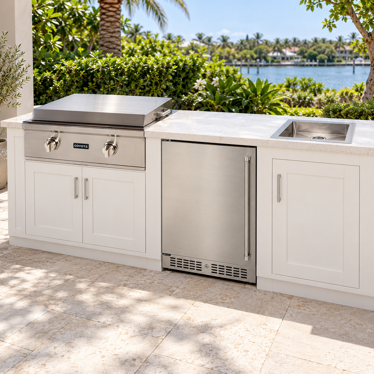 Coyote Flat Top Favorites Package – 30" Griddle, 24" Refrigerator & Drop-In Sink installed in an outdoor kitchen; cabinetry and setting shown for inspiration