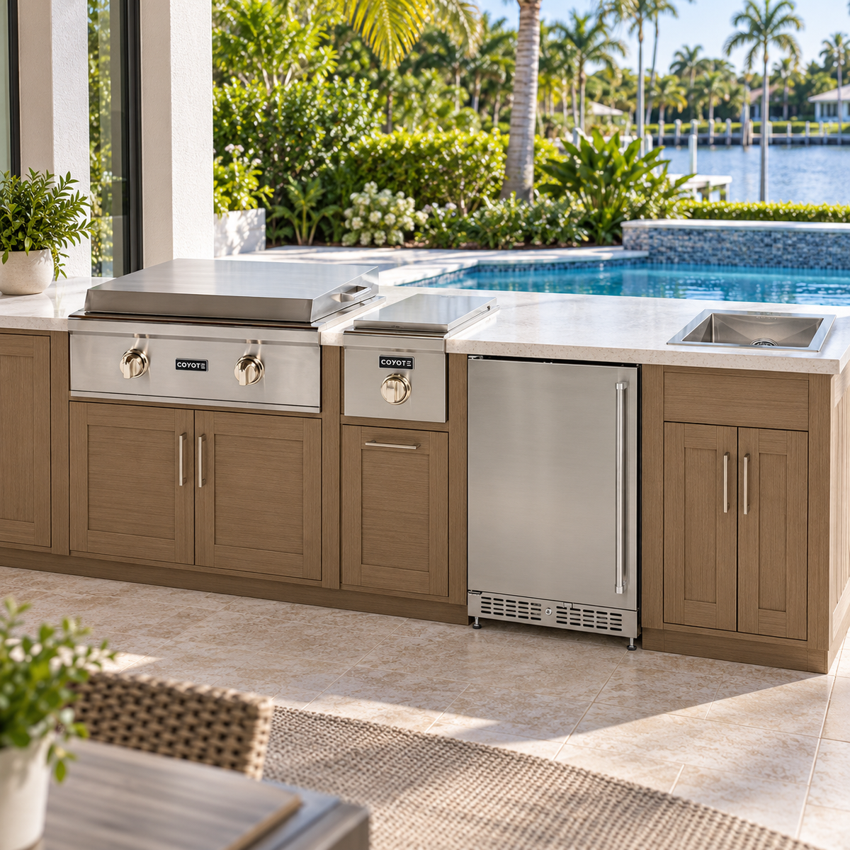 Coyote Griddle & Gather Package – 30" Griddle, 24" Refrigerator, Single Side Burner & Drop-In Sink installed in an outdoor kitchen; cabinetry and setting shown for inspiration